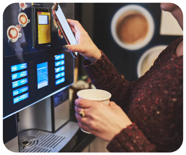 Woman getting coffee from coffee machine