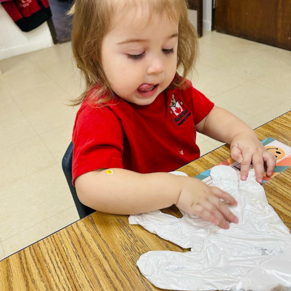 a child playing with a glove filled with paint