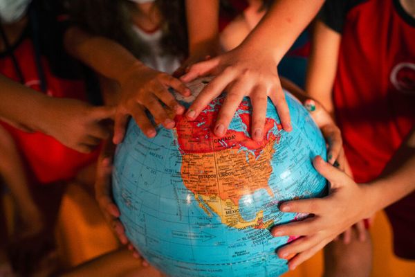 children's hands on a globe