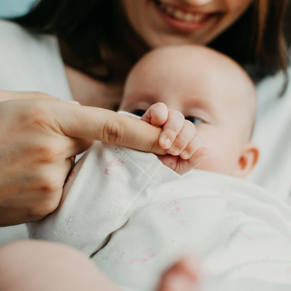 Baby holding mom's finger