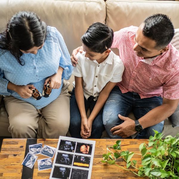 mom and dad showing son baby ultrasounds