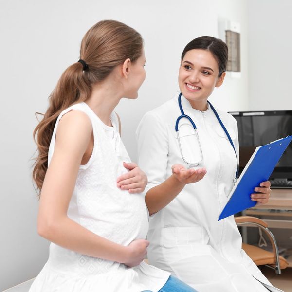 a pregnant woman talking with a doctor