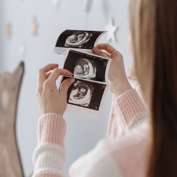 woman holding ultrasound photos