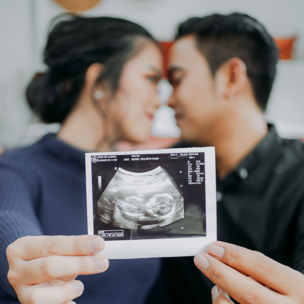 couple holding ultrasound picture