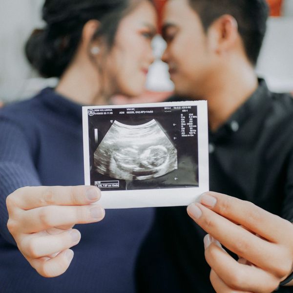 couple holding ultrasound picture of baby