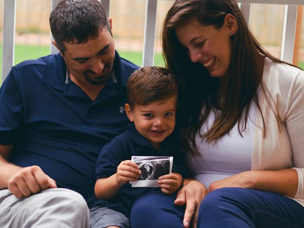 young family holding ultrasound image