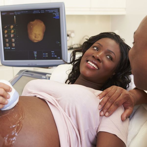 Mom and father smile at one another at 4D ultrasound appointment