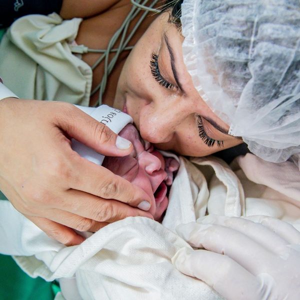 mom in the hospital kissing top of newborns head