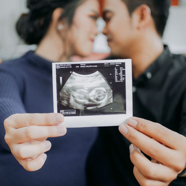 couple in background holding out ultrasound image