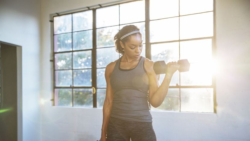 female-athlete-lifting-dumbbells-in-gym-royalty-free-image-1679413376.jpg