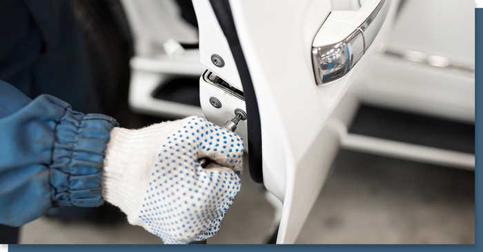 Locksmith working on the lock of a car door