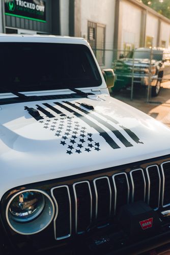 Distressed American flag vinyl decal custom applied to the hood of a Jeep Wrangler.