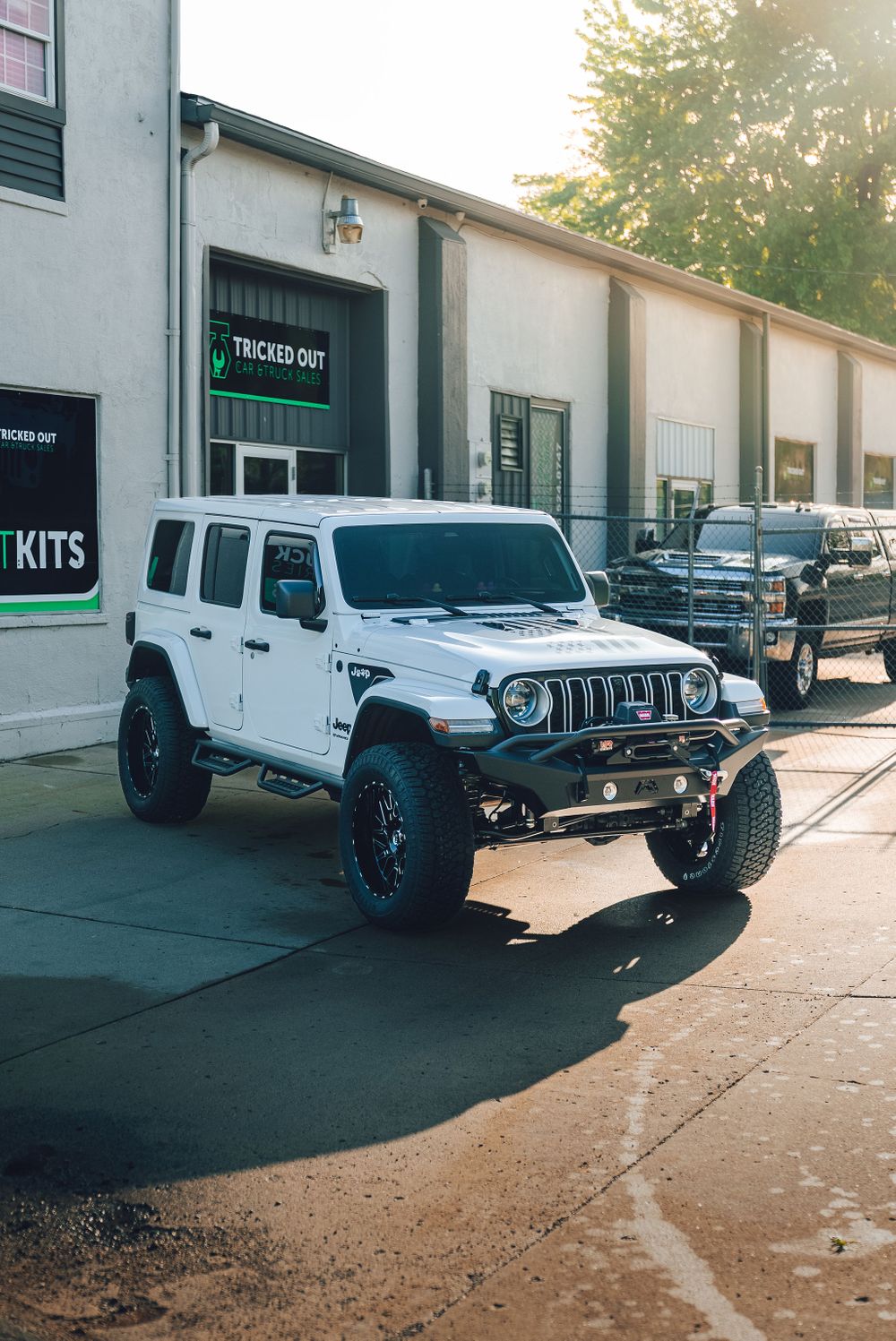Fully customized white Jeep Wrangler with aftermarket bumpers, lift kit, and off-road accessories.