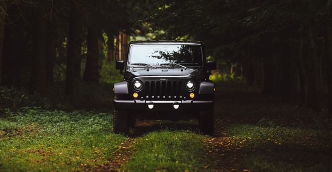 Black Jeep driving through the woods