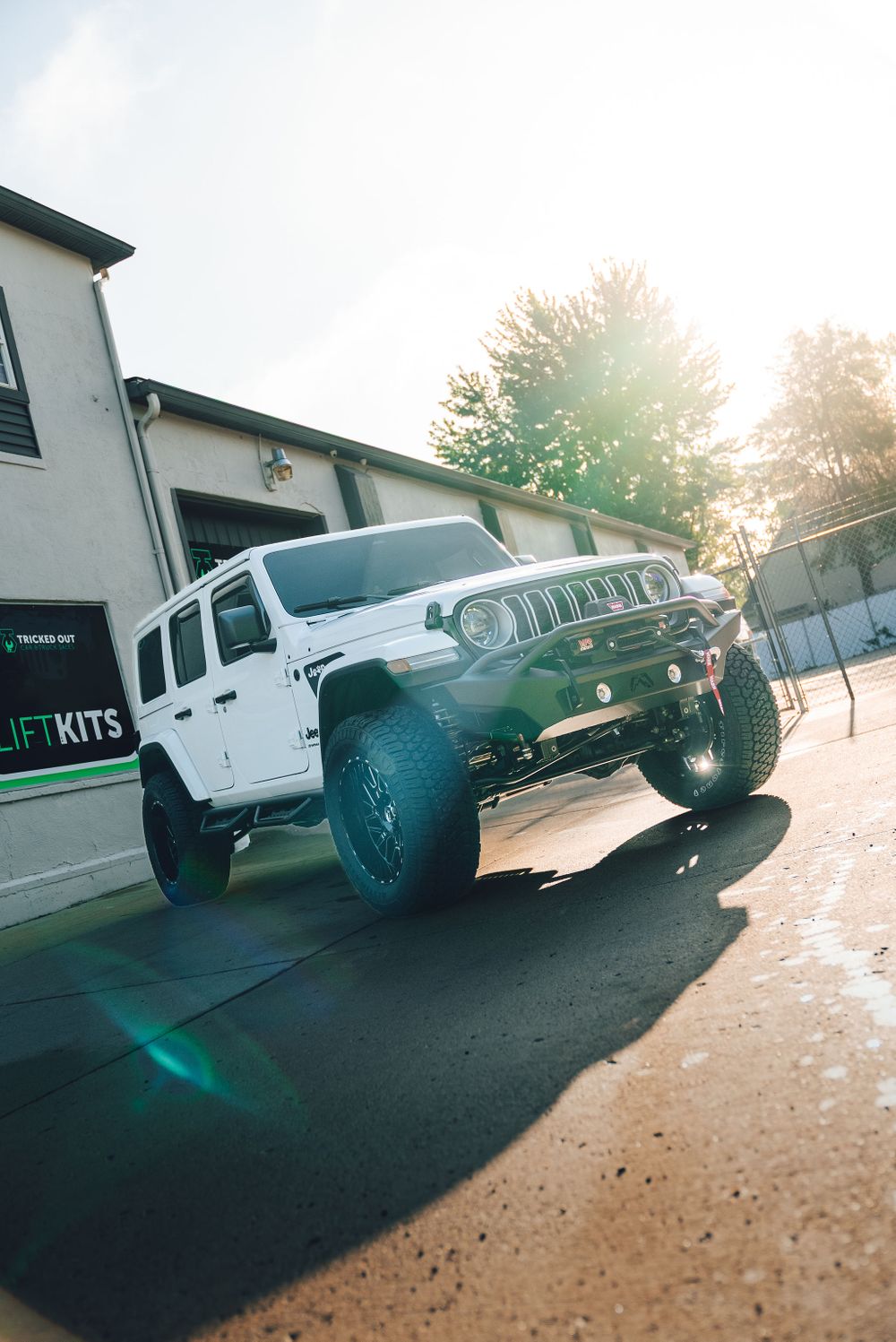 Low angle front view of lifted Jeep Wrangler showing ground clearance from Rough Country suspension.