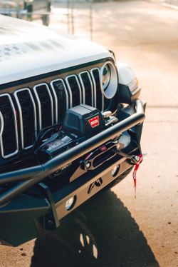 Off-road winch mounted securely inside a Fab Fours aftermarket front bumper on a Jeep.
