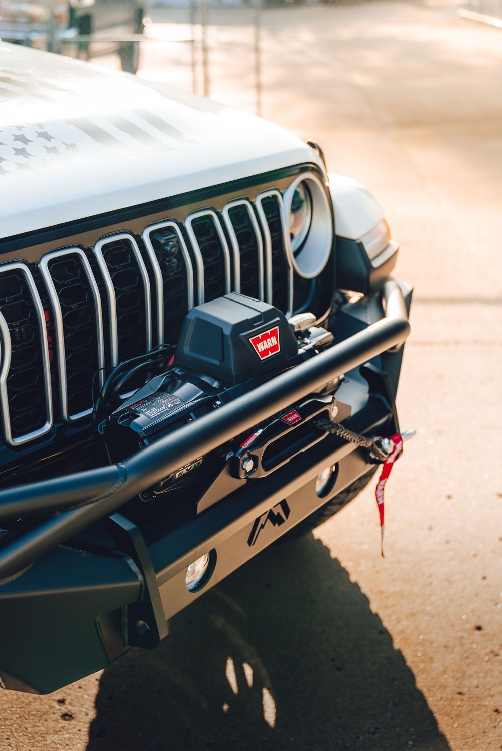 Off-road winch mounted securely inside a Fab Fours aftermarket front bumper on a Jeep.