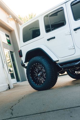 Close up of rear tinted windows on a white Jeep Wrangler using premium ceramic film.
