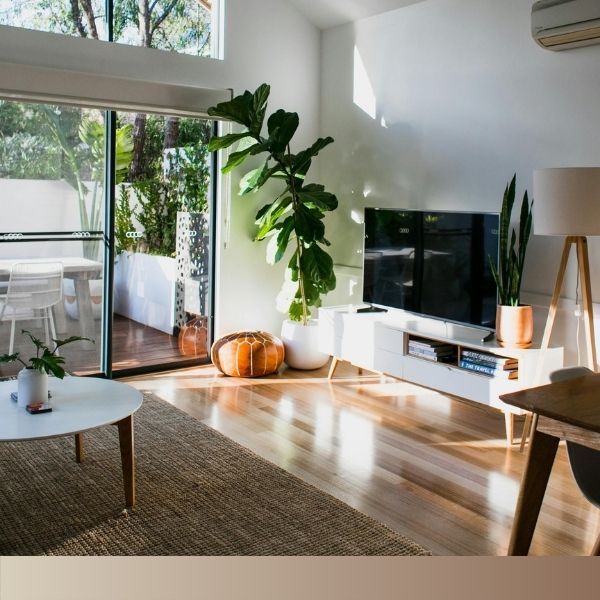 A hardwood floor seamlessly connects a traditionally furnished area with a modern, minimalist space, showcasing its stylistic versatility.