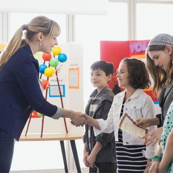 teacher shaking hands with students