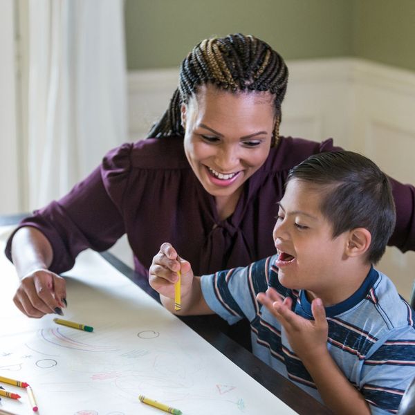 staff coloring with young boy with special needs