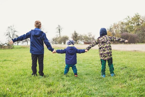 children holding hands in a field