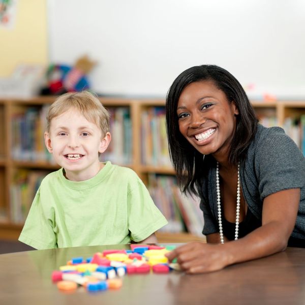 staff member working with young special needs boy on building blocks