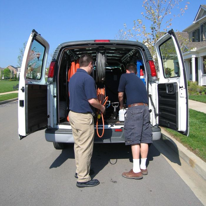 two workers getting equipment out of an organized utility van