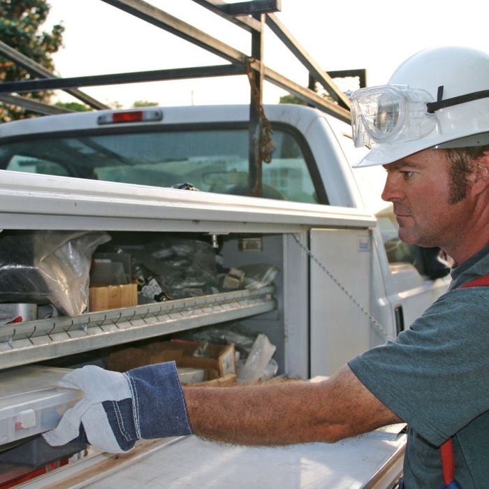 a worker pulling equipment out of a van organizational drawer