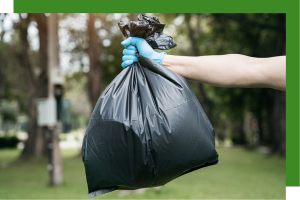 holding out a trash bag