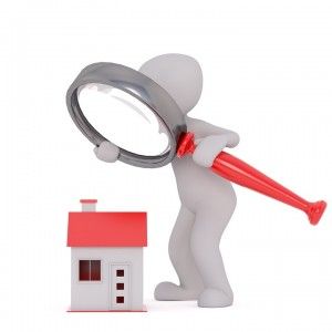 figure holding a magnifying glass over a house