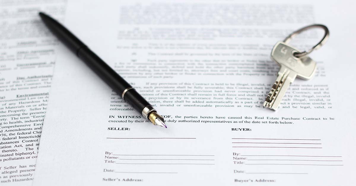 A pen and key sitting on top of a real estate document of Speedy Title & Escrow Company