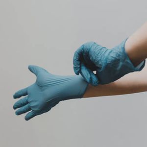 person putting on rubber gloves