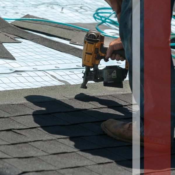 A roofer installing nails onto a shingle