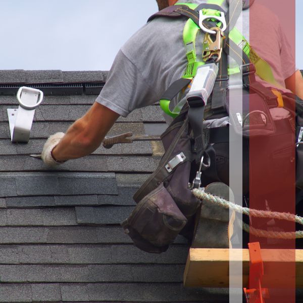 A roofer installing shingles