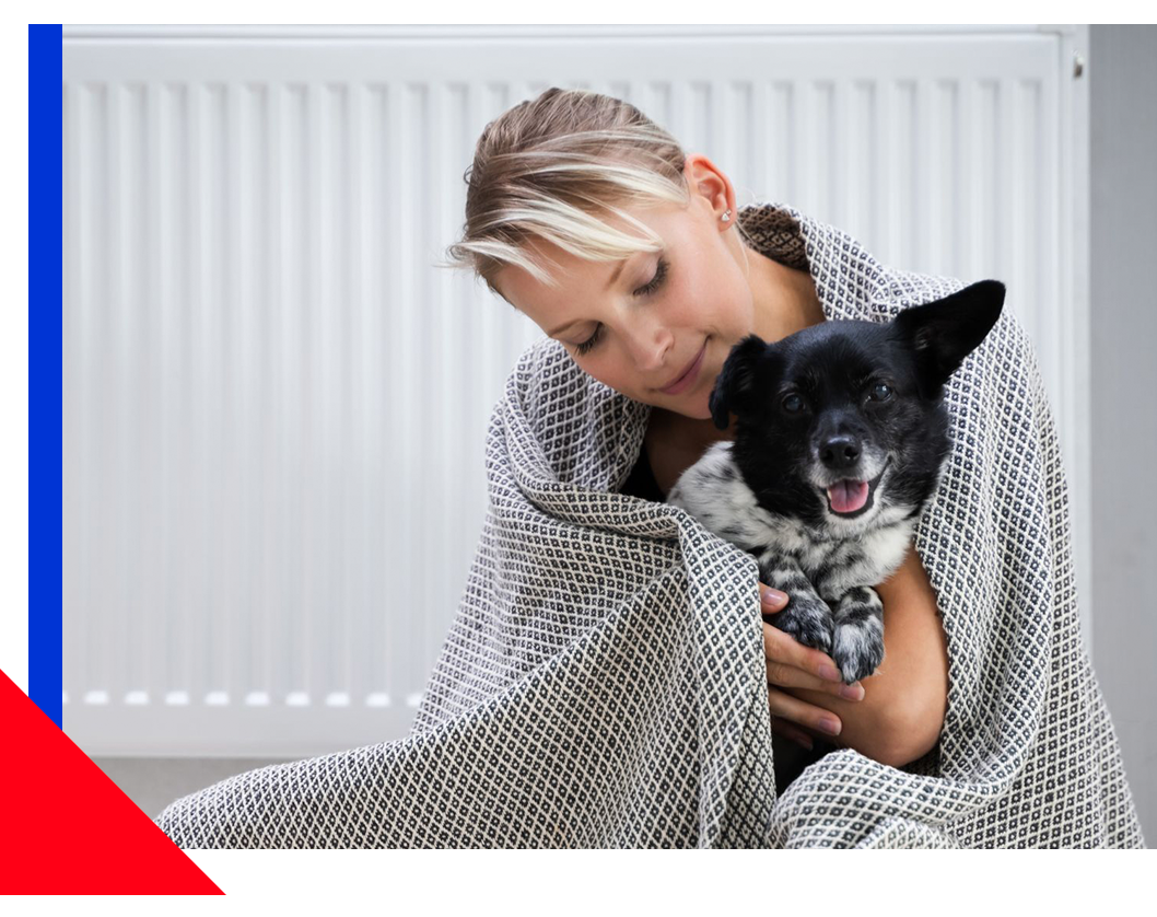 Woman in blanket cuddling dog