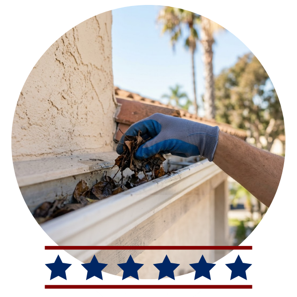 A 1:1 ratio image that is a close up showing a hand cleaning the gutters of a San Diego home.