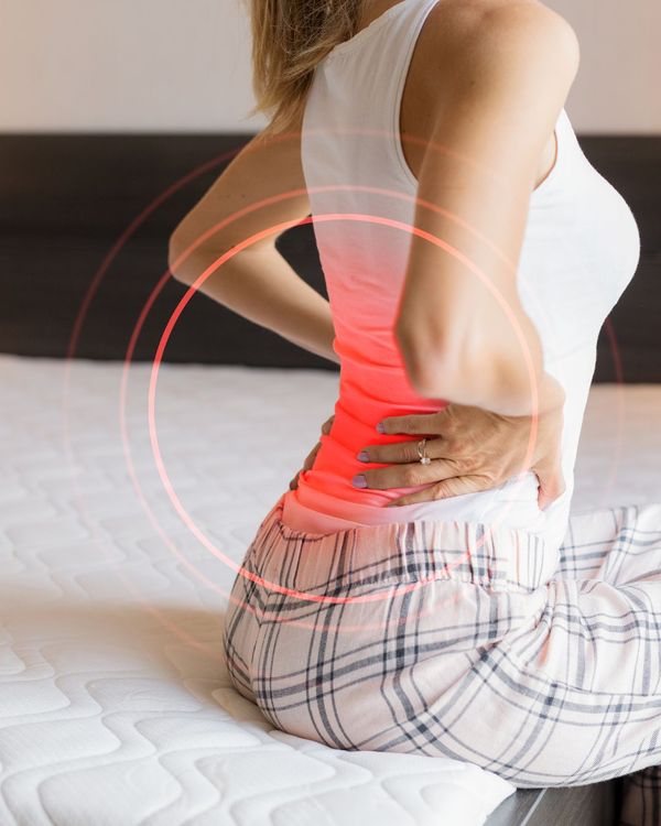 Woman wakes up from bad sleep with back pain
