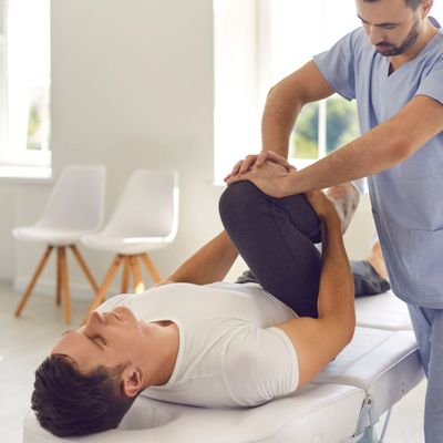 Chiropractor stretching patient's leg