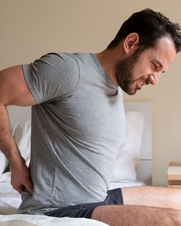 A man wakes up from sleep with back pain