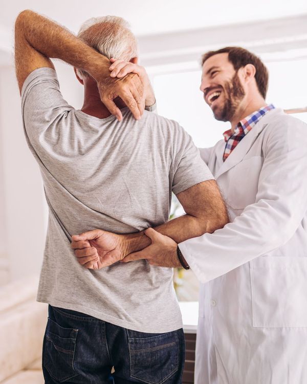 Chiropractor helps elderly man with his spine