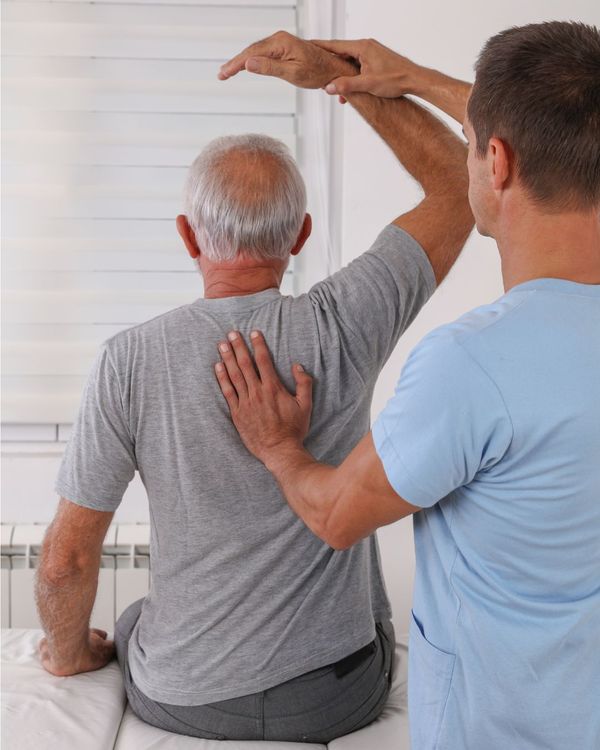 Chiropractor helps elderly man with flexibility