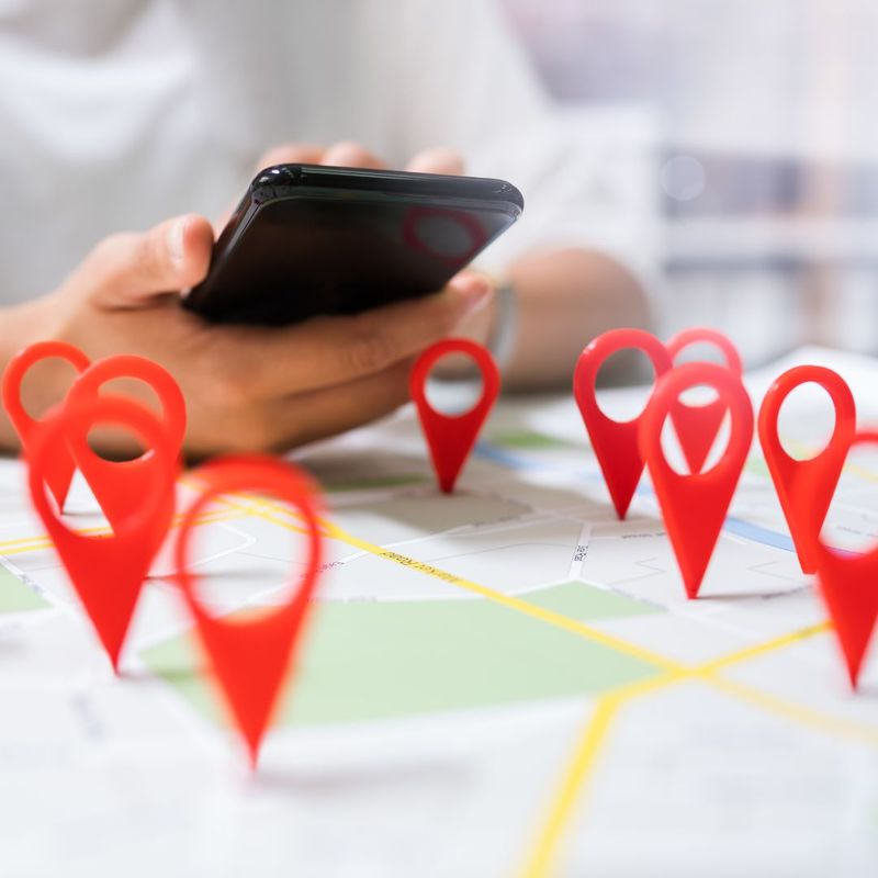 person on cell phone looking at points on a map
