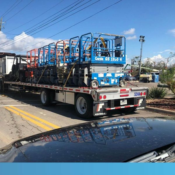 construction equipment on the back of a tractor trailer
