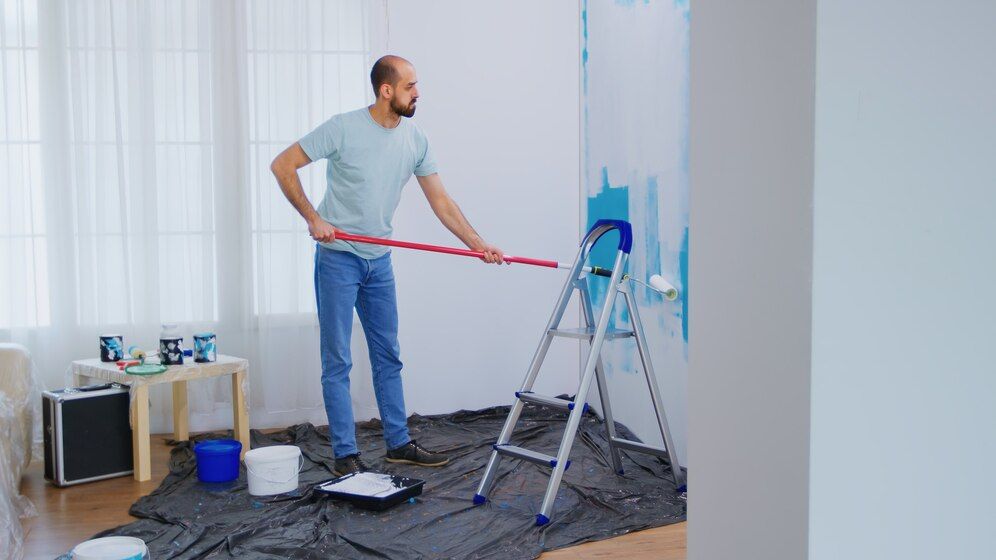 masaking-blue-paint-with-roller-brush-dipped-white-paint-handyman-renovating-apartment-redecoration-home-construction-while-renovating-improving-repair-decorating_482257-14191.jpeg