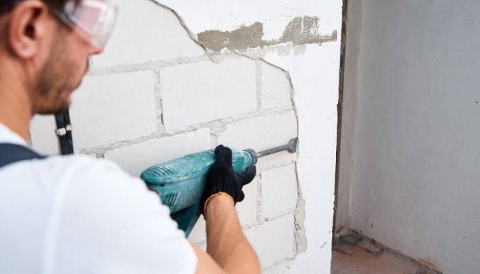 prepping for new stucco application by removing old broken stucco