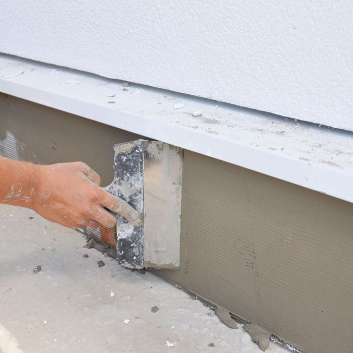 contractor applying stucco to home