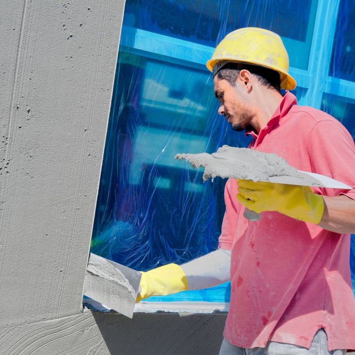 stucco contractor working near window