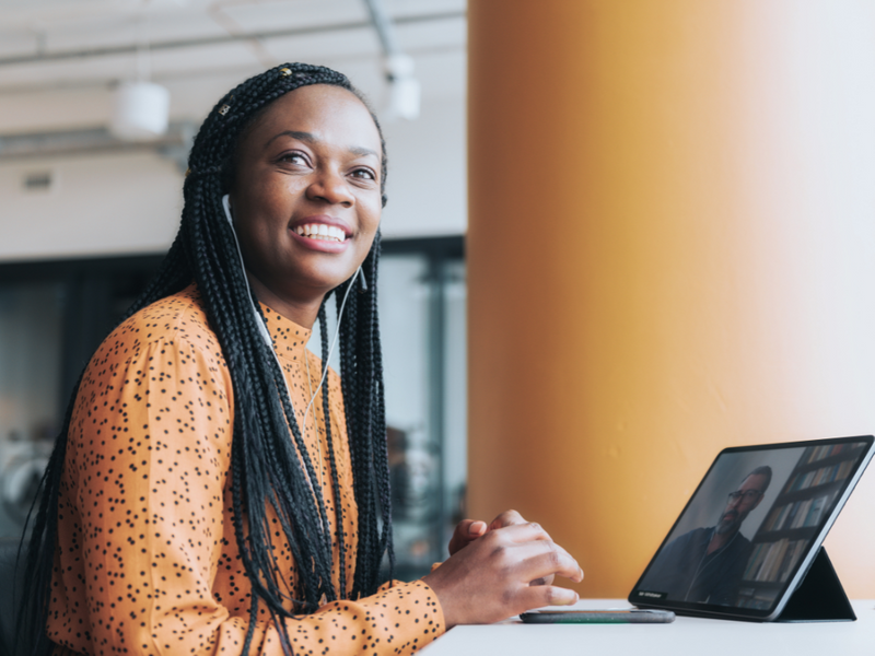 An African American woman smiling while looking away from her computer