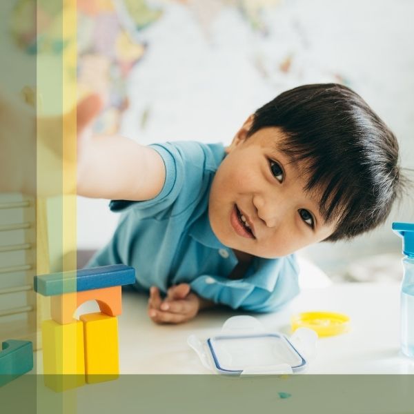 Preschool Child Leaning Over Desk Reaching Out